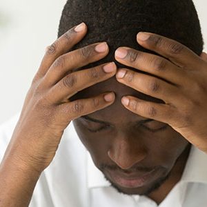 living with uncertainty during the corona virus. man with if hands on his head worried about the future.