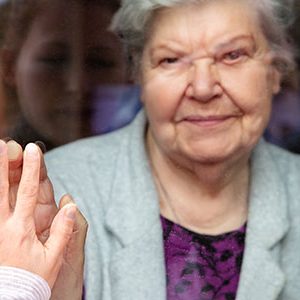 how to stay social during social distancing. Daughter seeing her mum from a glass window.