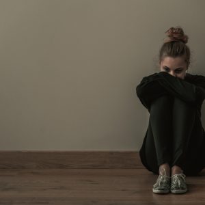 woman sitting down with signs of mental health