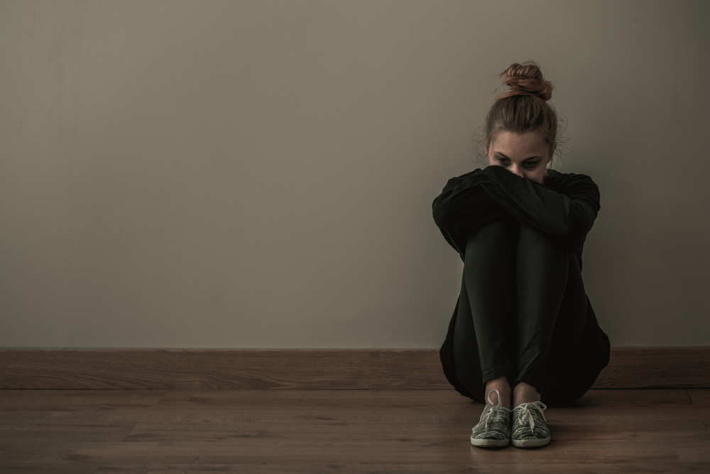 woman sitting down with signs of mental health