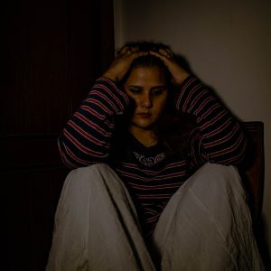 depressed woman sitting with hands on her head