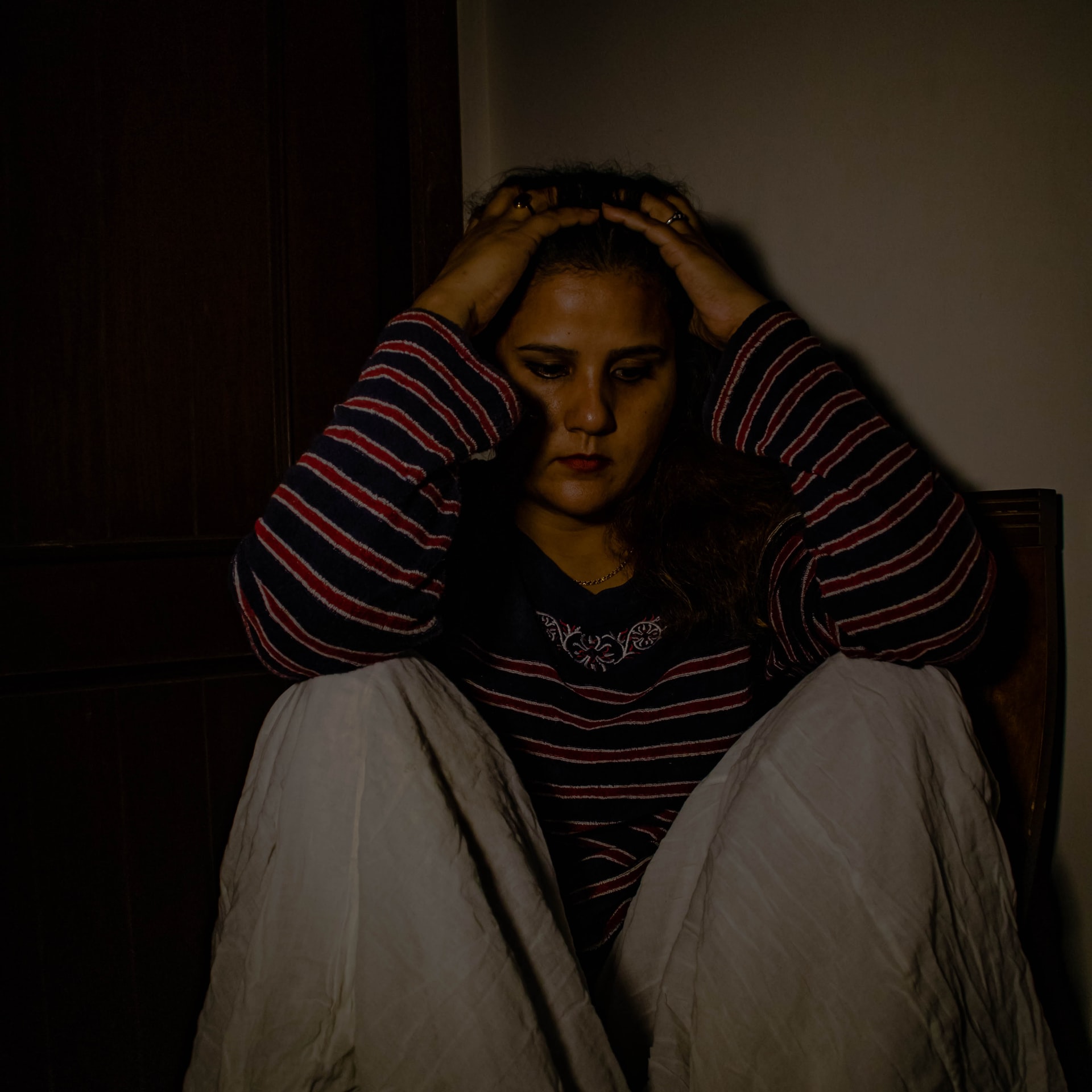 depressed woman sitting with hands on her head