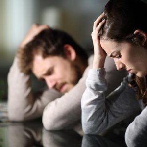 Sad couple complaining after argument in the night at home