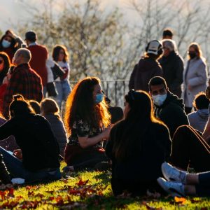 People socialise and relax no the grass