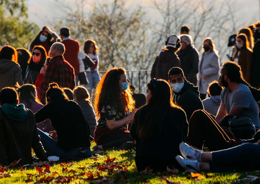 People socialise and relax no the grass